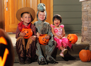 Children sitting on house porch - AAA Halloween Safety