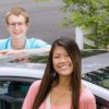 4 teenage drivers stand near car in driveway